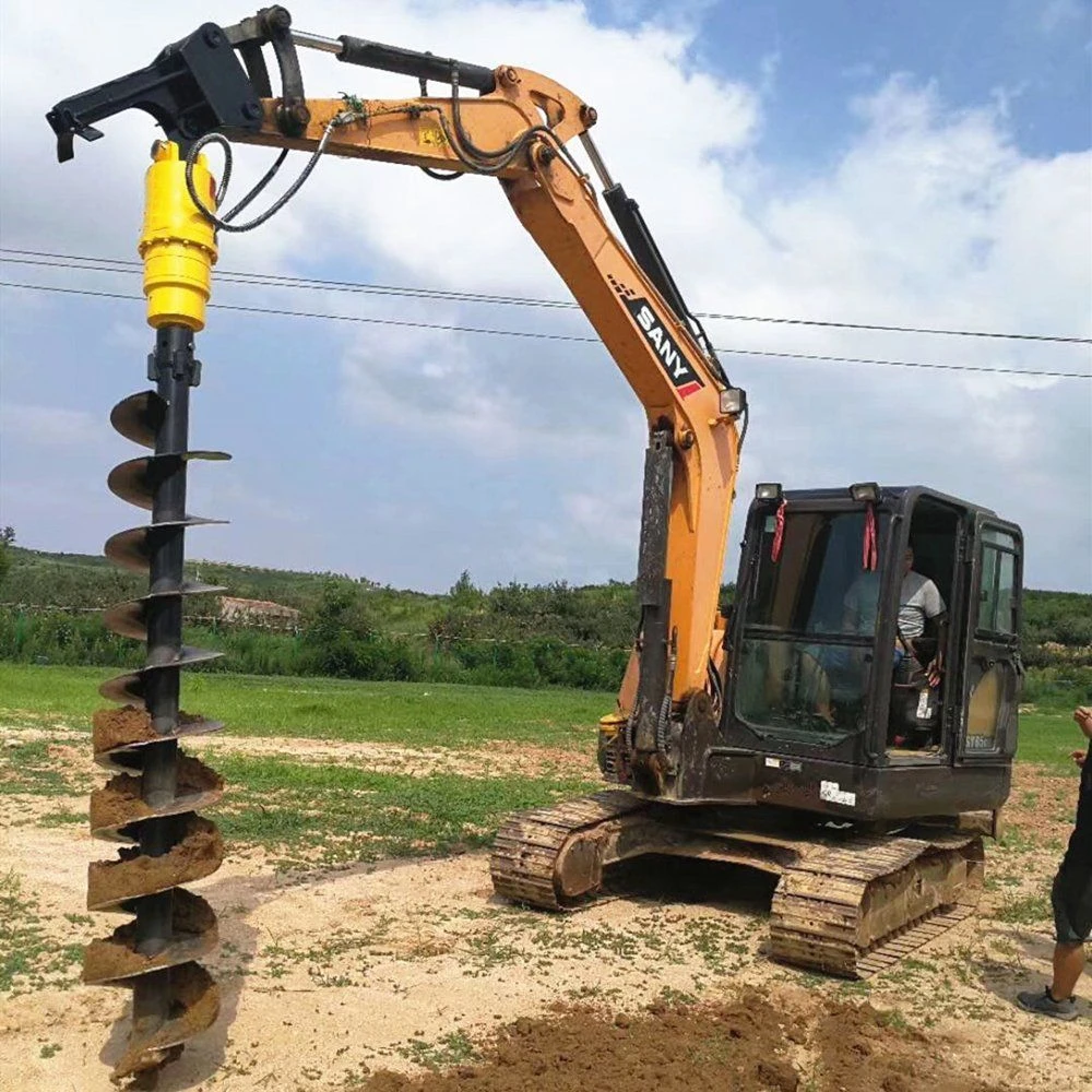 Excavator with a hydraulic auger and soil-covered drilling flights at a field site