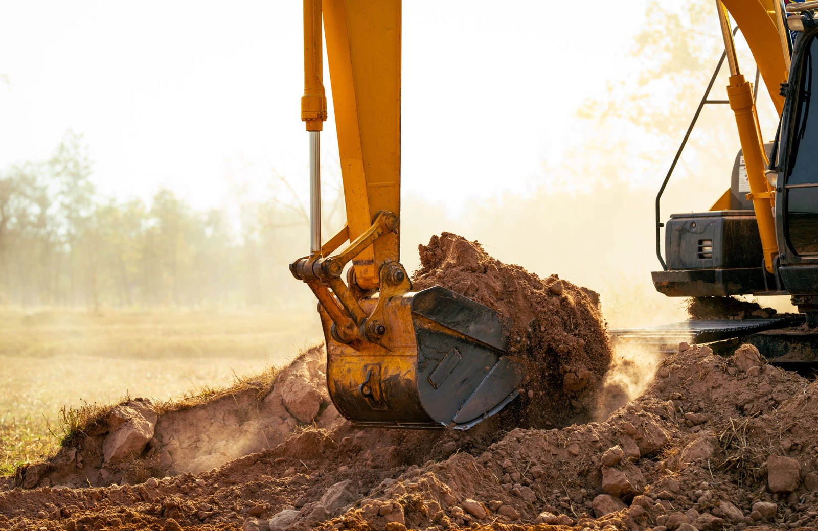 Excavator bucket gathering soil during earthwork