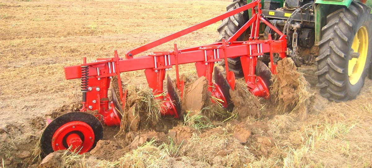 Tractor pulling a tine cultivator through residue-bearing field soil