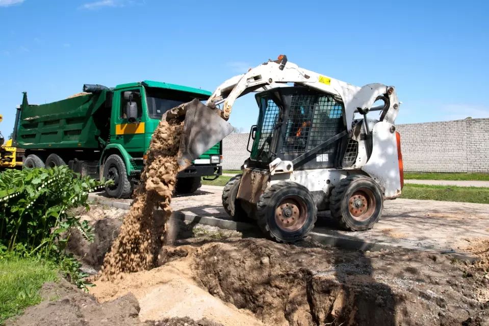 Wheeled skid-steer loader handling soil