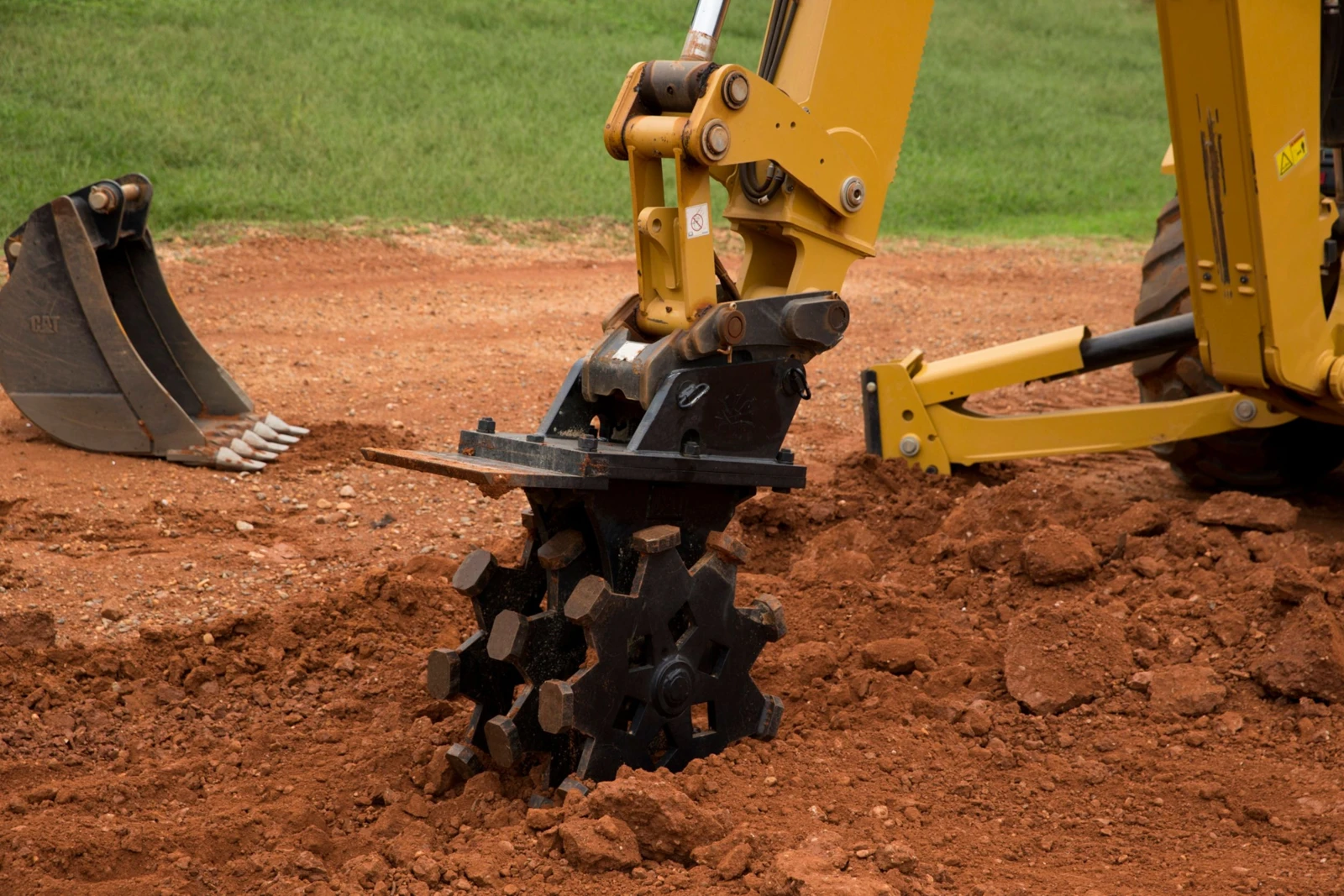 Soil compaction with an excavator-mounted compaction wheel