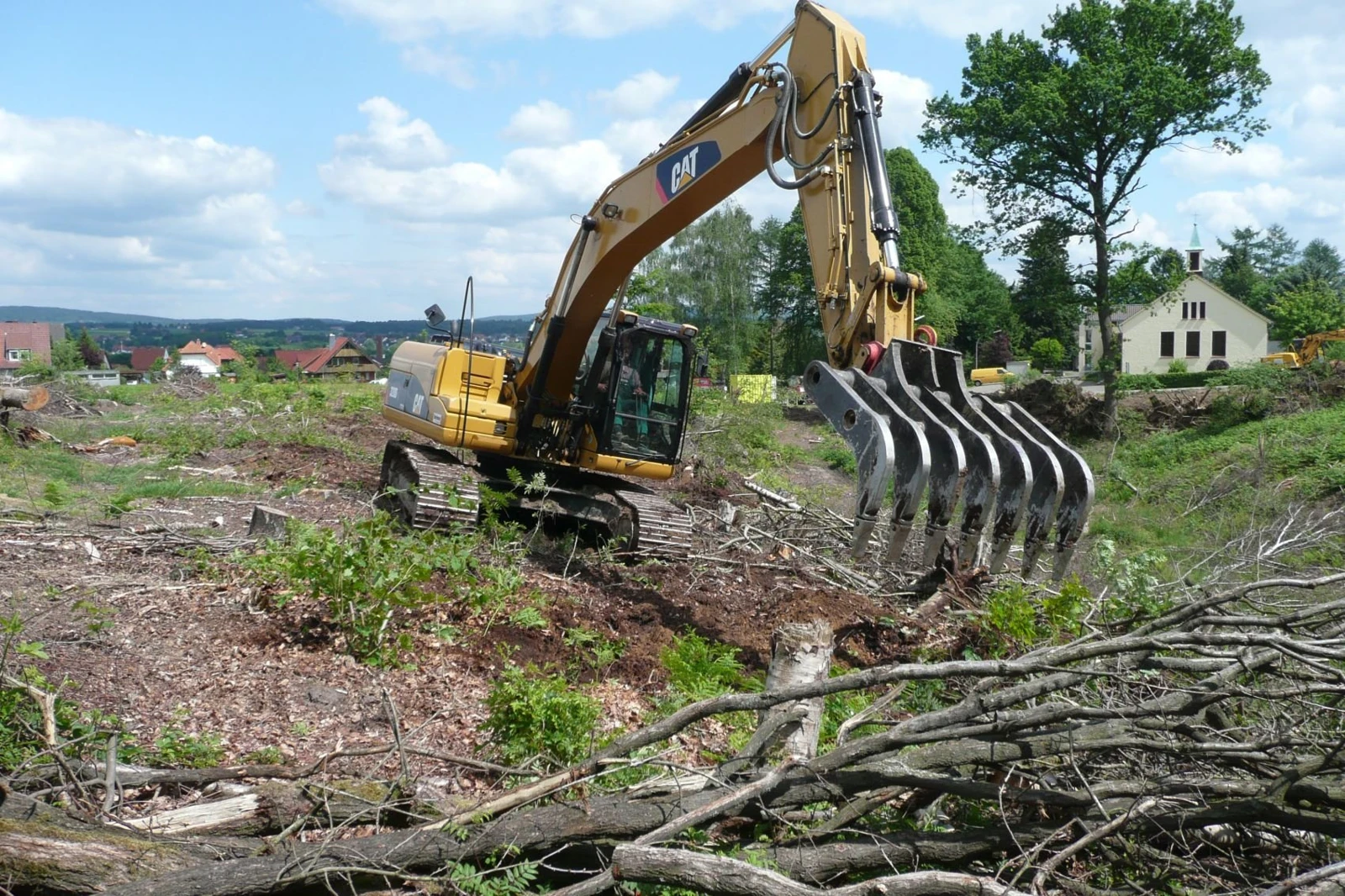 Brush and root clearing with an excavator rake