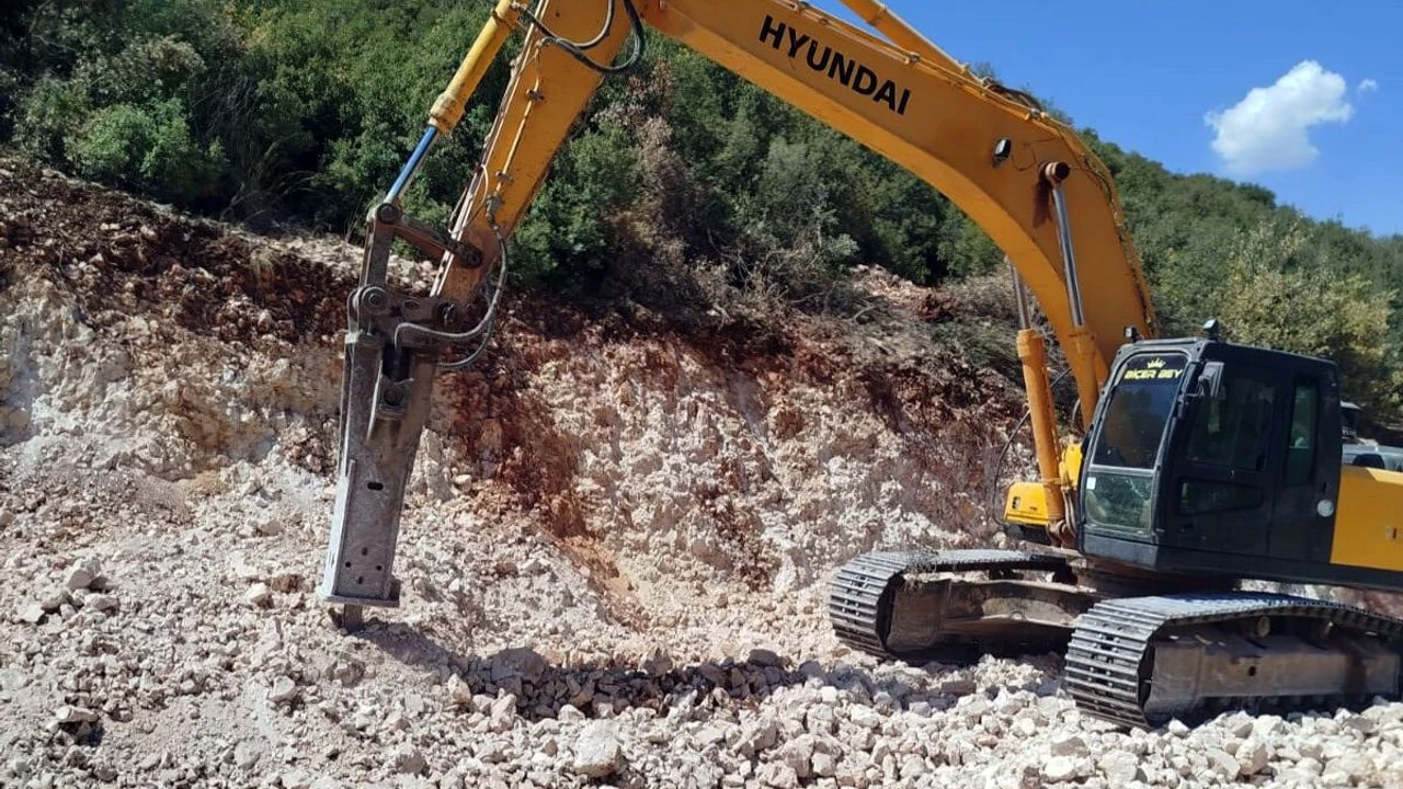 Rock breaking with a side-mounted hydraulic breaker