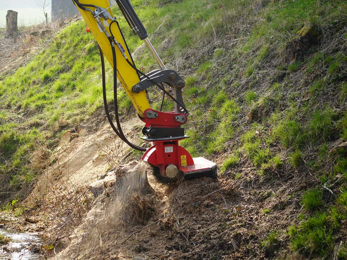 Tree-stump grinding with an excavator-mounted grinder