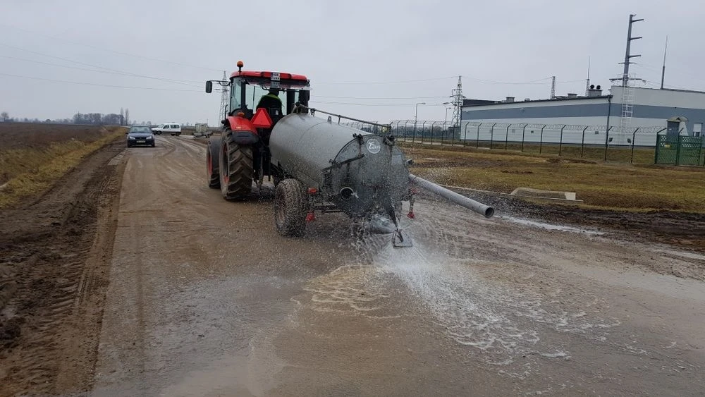 Water spraying from a tractor-towed water bowser